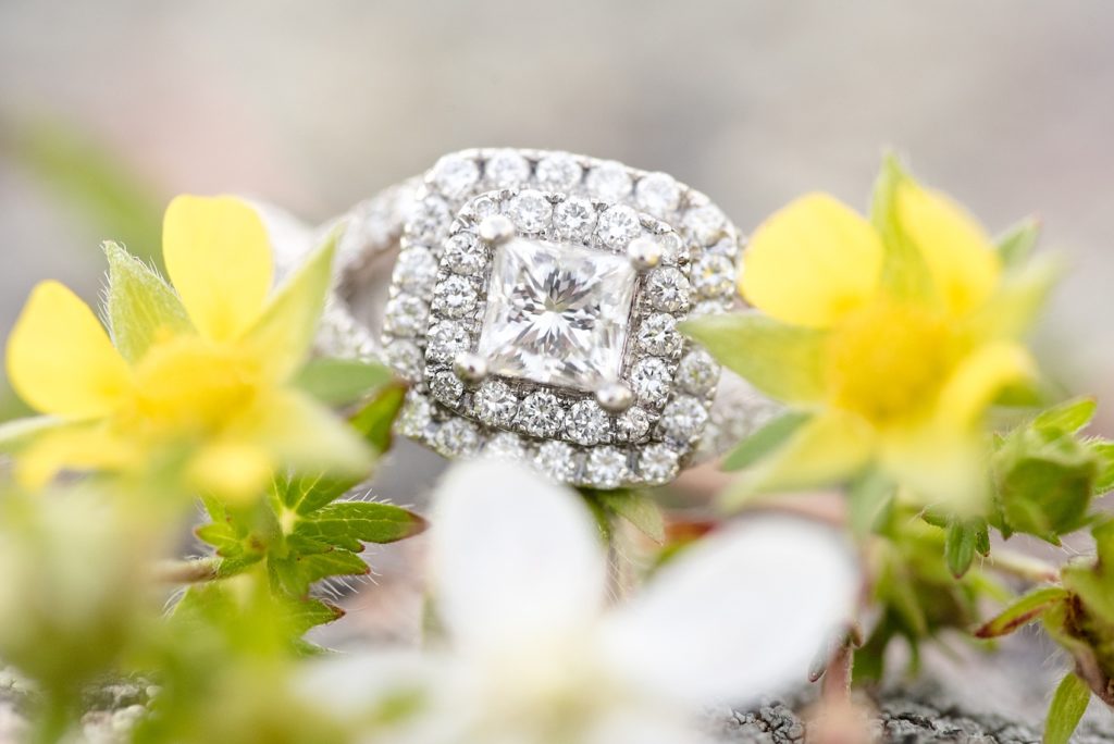Beautiful up close shot of an engagement ring sitting on wildflowers
