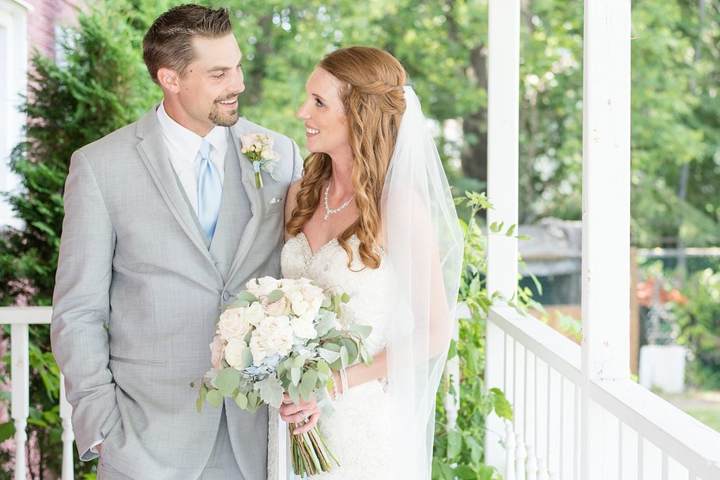 Bride and groom standing on the porch of a beautiful private home