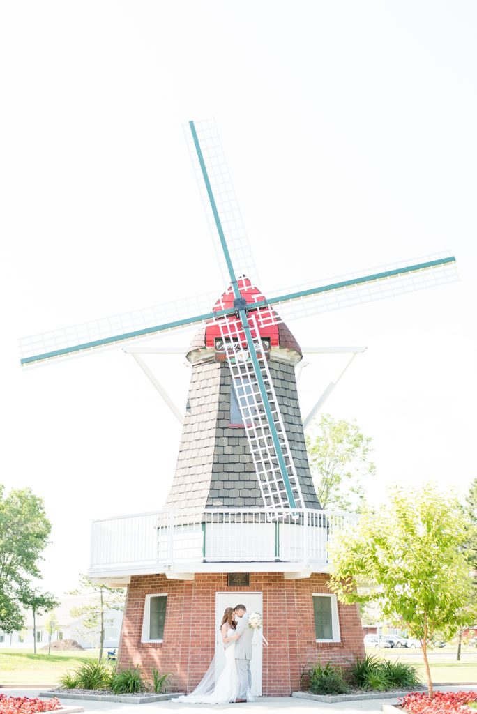 Bride and groom kissing in front of windmill