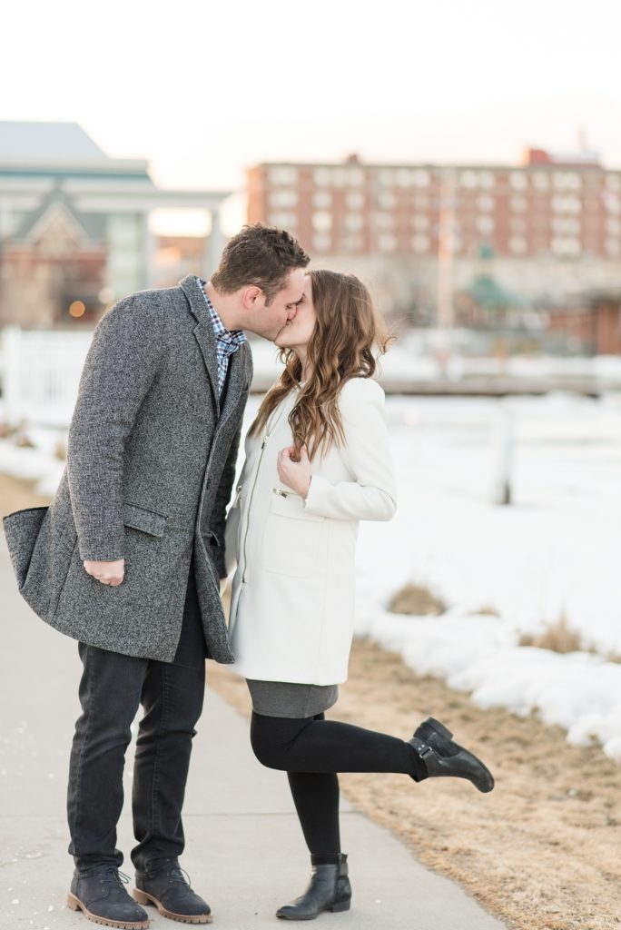 A Toronto couple shares a kiss during their winter engagement session at Marina Park in Thunder Bay