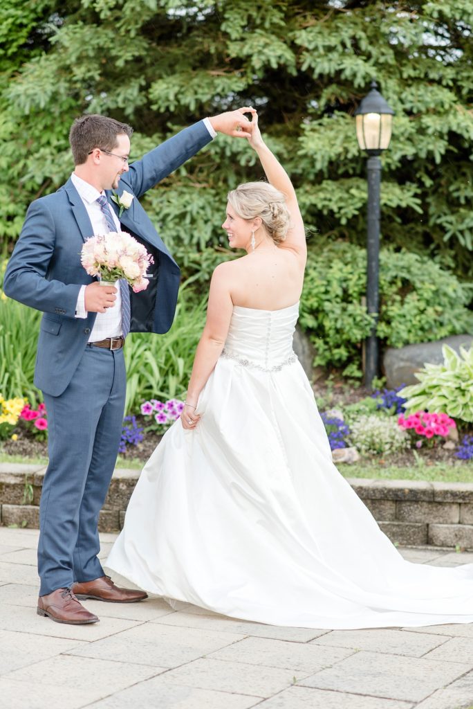Groom twirls his bride in the garden at Nor'Wester in Thunder Bay