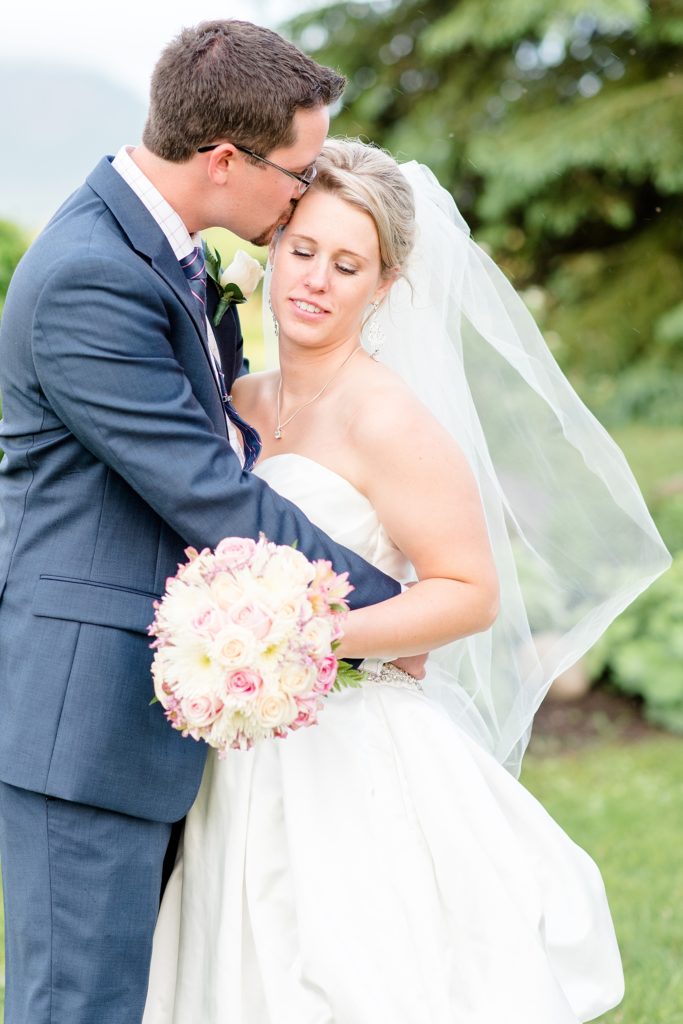 Bride and groom snuggling romantically during portraits