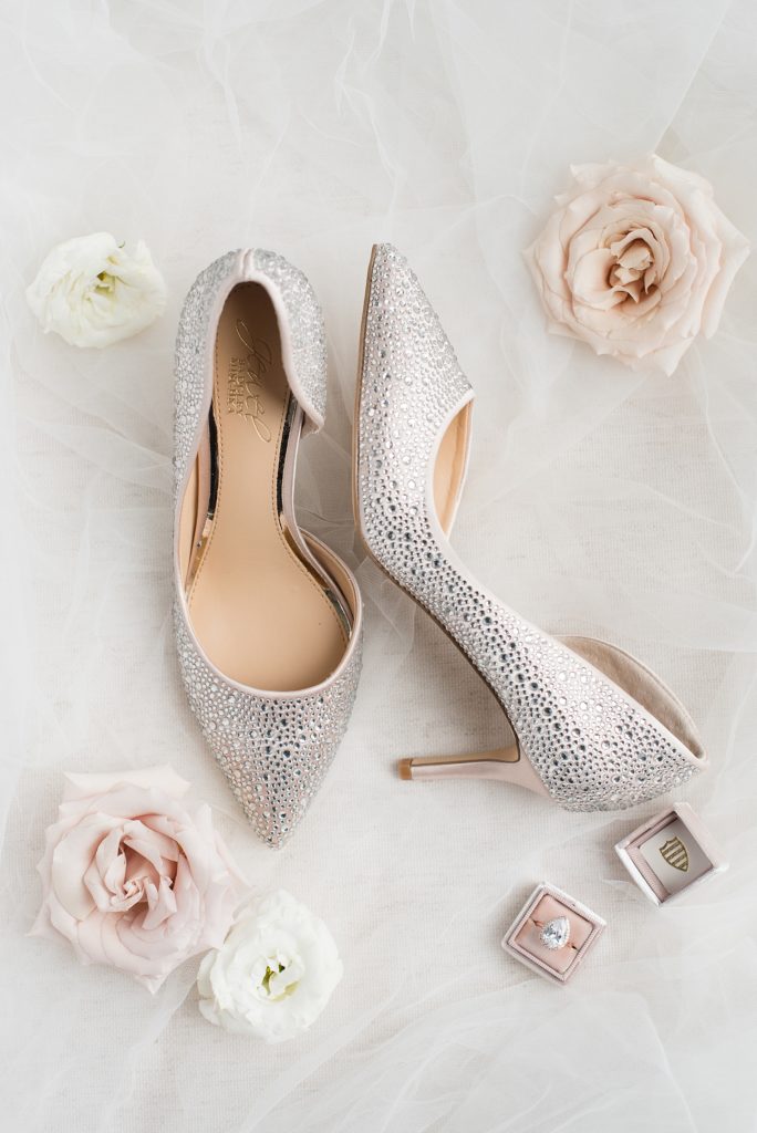 Badgley Mischka wedding shoes surrounded by roses and a pink heirloom ring box