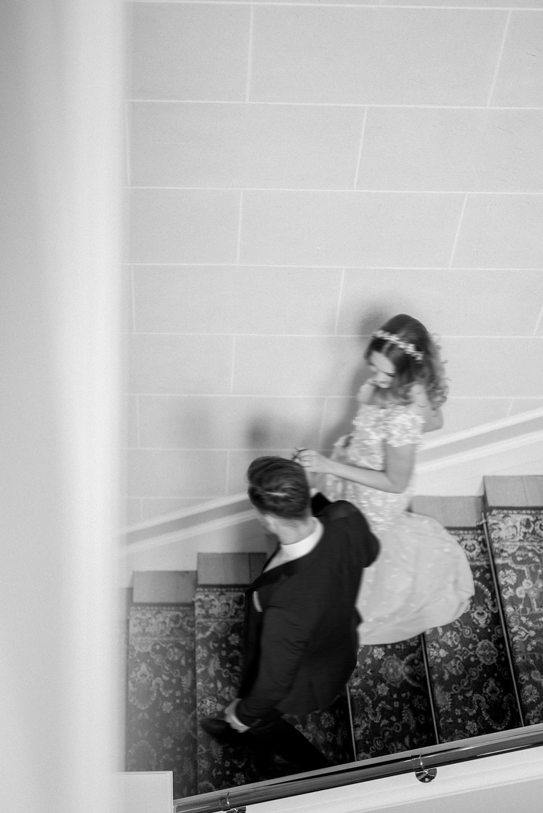 Bride and groom descending an inner staircase at Chateau Bouffemont